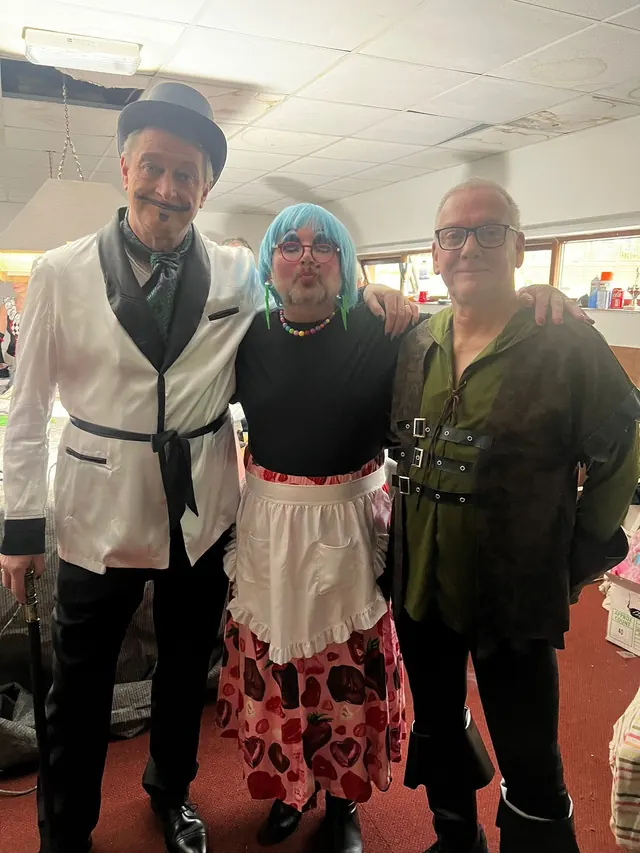 Costumed cast members together backstage